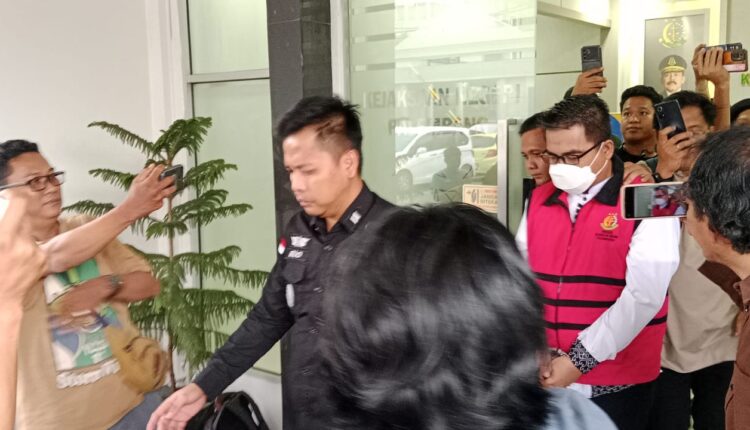 Tersangka kasus dugaan korupsi pemeliharaan lampu jalan mengenakan rompi tahanan saat digiring petugas menuju mobil tahanan di Kantor Kejaksaan Negeri (Kejari) Palembang, Sumatera Selatan.
