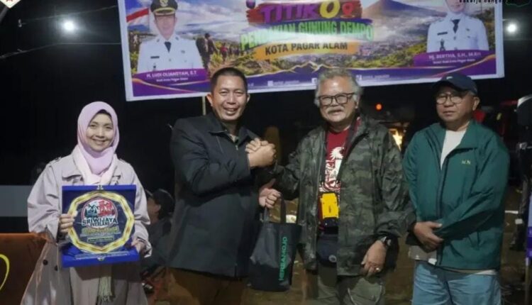 Walikota Pagar Alam, Ludi Oliansyah, berjabat tangan erat dengan penjelajah senior sekaligus Owner Happy Go Lucky (HGL) Overland Indonesia, Hartawan Setjodiningrat atau Om Hauwke, disaksikan Wakil Walikota Bertha yang memegang plakat Sriwijaya Overlanding saat acara peluncuran Titik 0 (nol) Pendakian Puncak Gunung Dempo dan Camping Ground "Serame" di Kampung IV, Kota Pagar Alam, Sumatera Selatan.