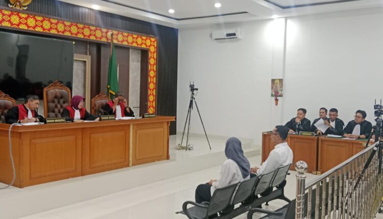 Terdakwa Titin Rita Lestari bersama terdakwa Augusz Dewanggara alias Angga mendengarkan pembacaan surat dakwaan oleh Jaksa Penuntut Umum (JPU) KPK RI dalam sidang perdana di Pengadilan Tindak Pidana Korupsi (Tipikor) pada Pengadilan Negeri Palembang, Sumatra Selatan.