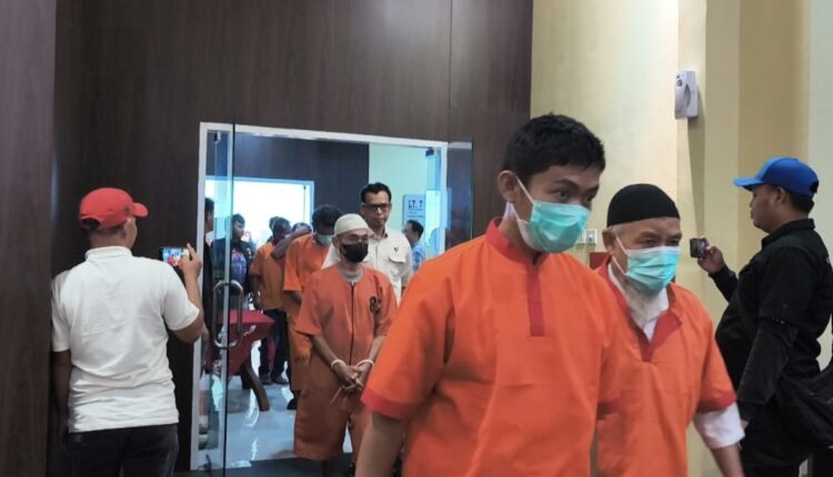 Sejumlah tersangka kasus kebakaran hutan dan lahan (karhutla) dengan tangan terikat mengenakan baju tahanan keluar dari ruang konferensi pers di Markas Kepolisian Daerah Sumatera Selatan (Polda Sumsel).